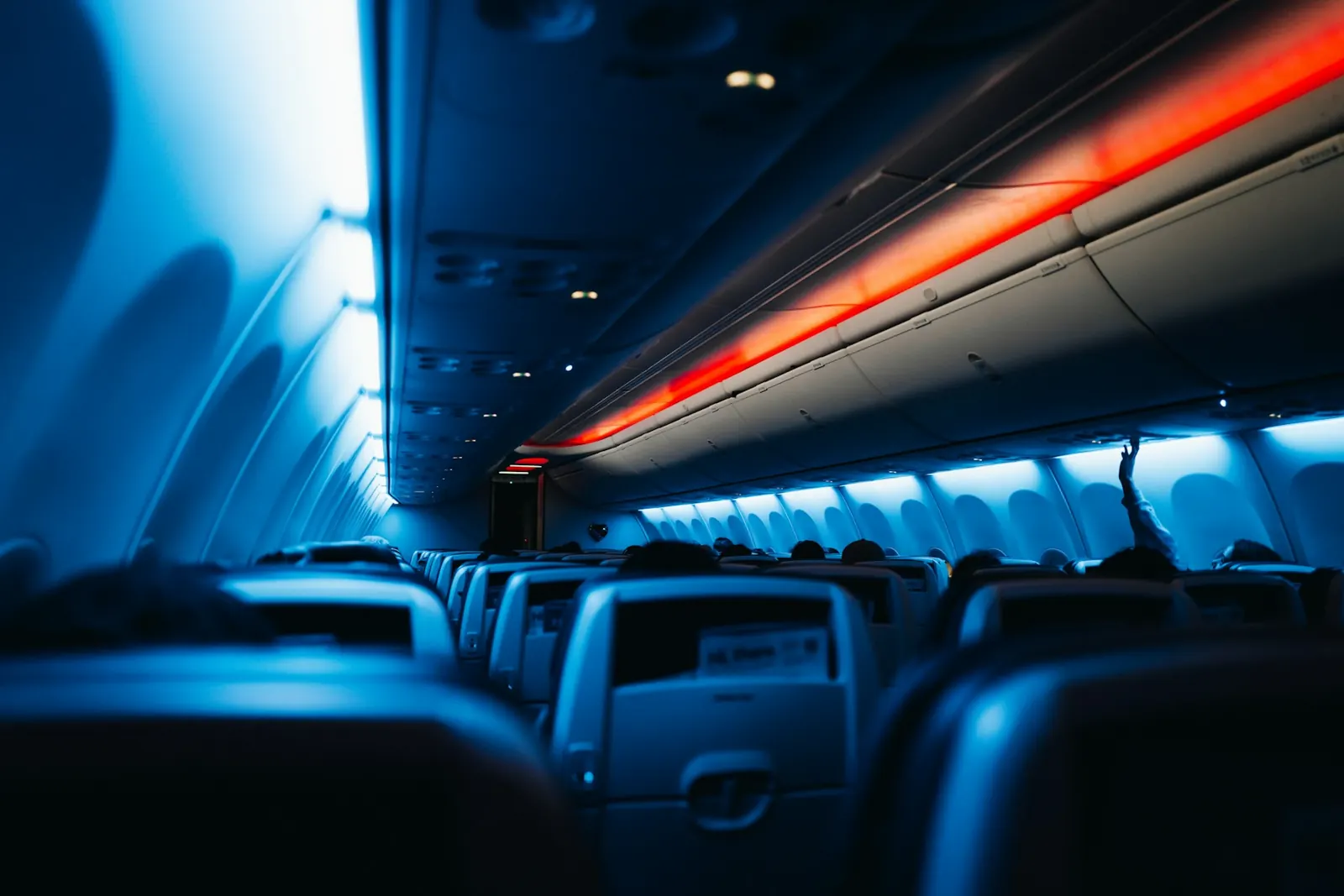 Overhead baggage compartments and seats inside an aircraft cabin.