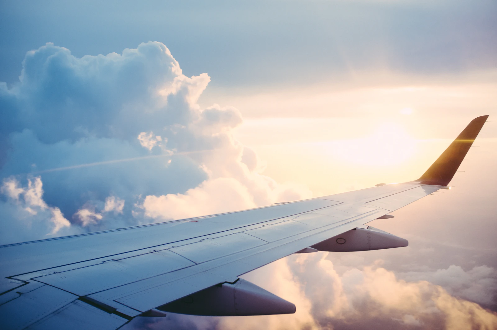 An aircraft wing above the clouds.